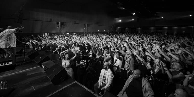 Festival crowd with raised hands facing the stage